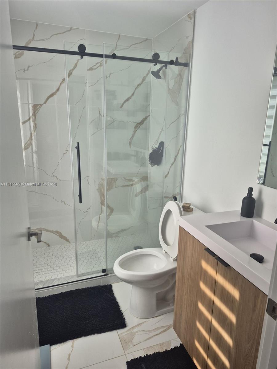 14515 Southwest 261st Street, Unit 14515 Homestead, FL 33032 - Photo 3 of 13 a bathroom with a sink toilet and shower