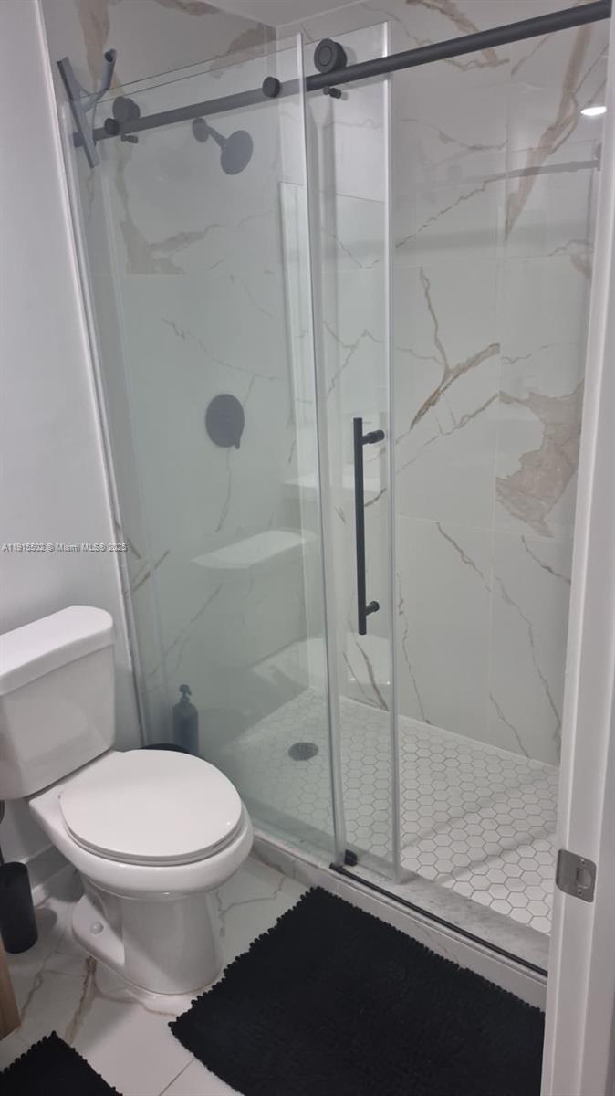 14515 Southwest 261st Street, Unit 14515 Homestead, FL 33032 - Photo 5 of 13 a white toilet next to a bathroom