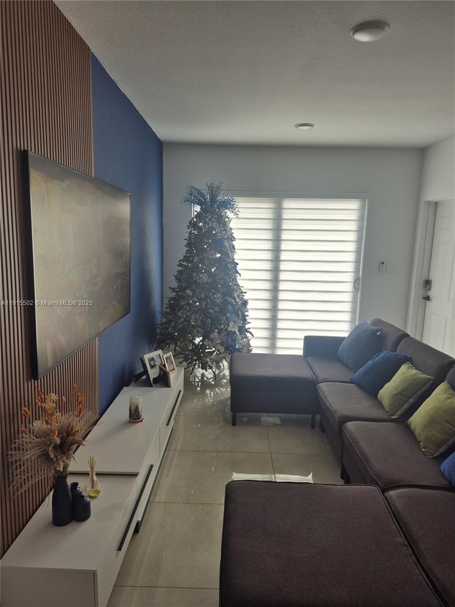 14515 Southwest 261st Street, Unit 14515 Homestead, FL 33032 - Photo 6 of 13 a living room with furniture and a large window