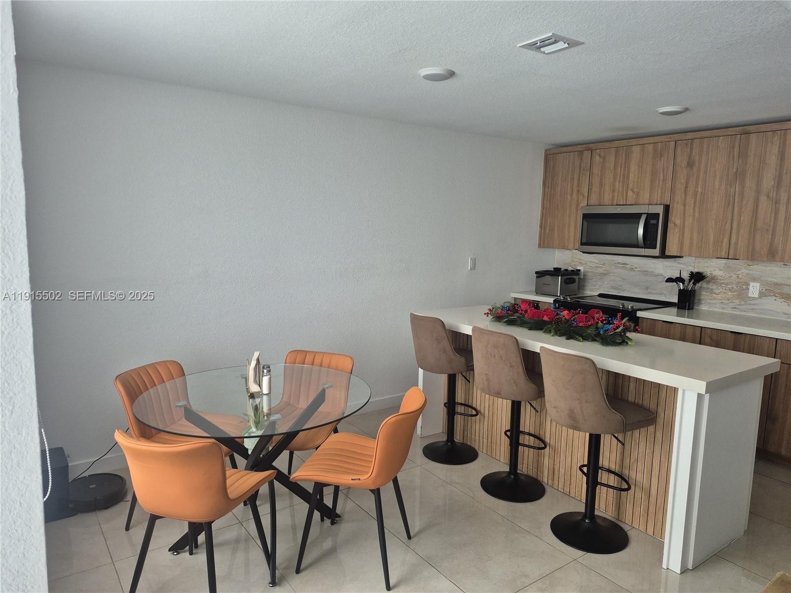 14515 Southwest 261st Street, Unit 14515 Homestead, FL 33032 - Photo 9 of 13 a view of a dining room with furniture and wooden floor