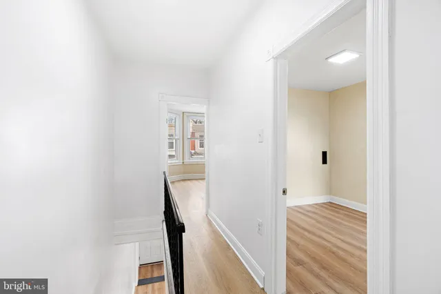 a view of a hallway with wooden floor and entryway