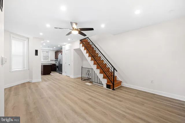 a view of a livingroom with wooden floor and staircase