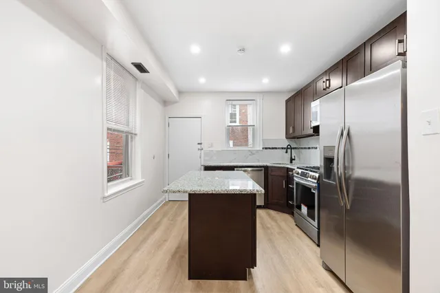 a kitchen with stainless steel appliances granite countertop refrigerator sink and stove