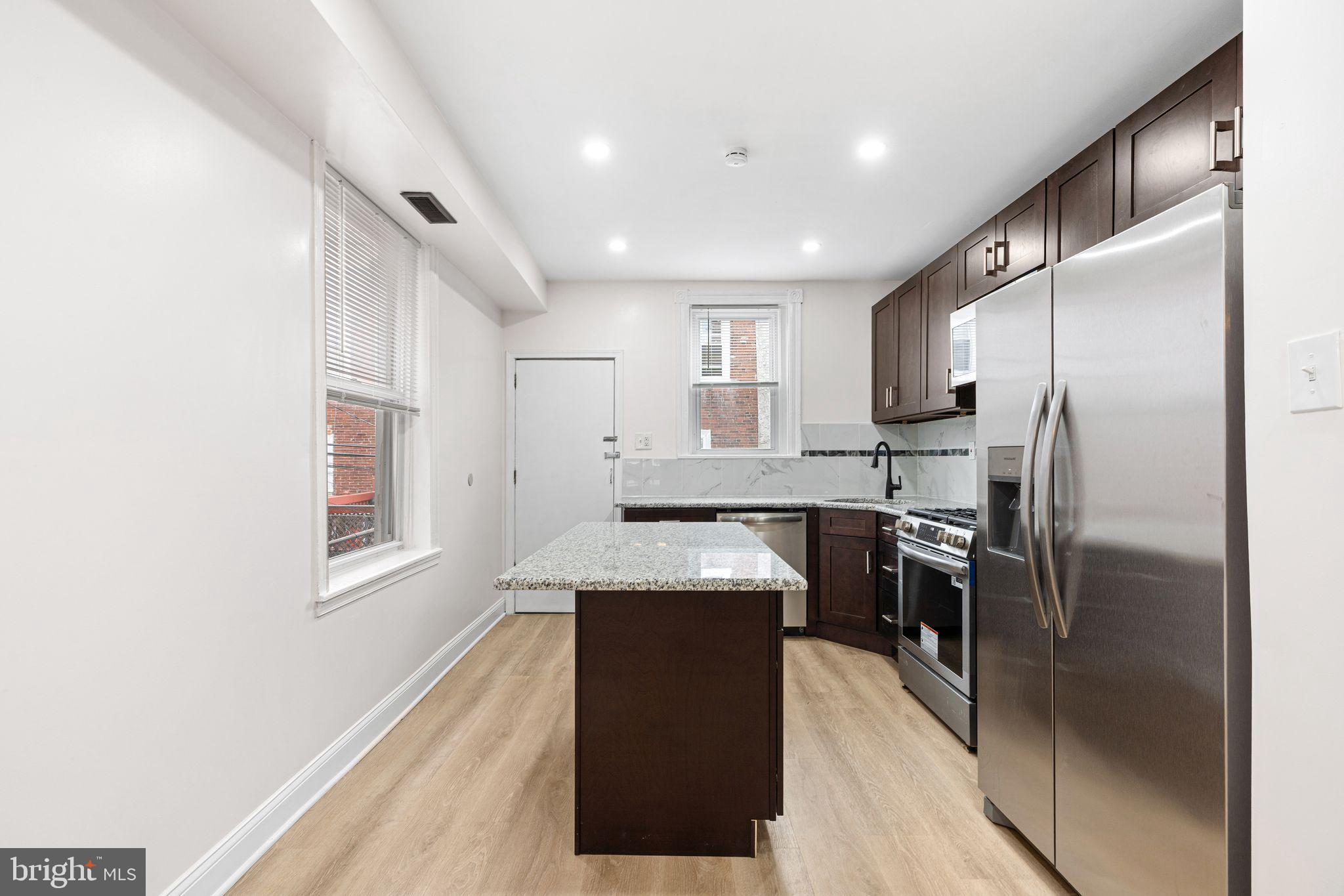 5428 Regent Street Philadelphia, PA 19143 - Photo 6 of 28 a kitchen with stainless steel appliances granite countertop refrigerator sink and stove