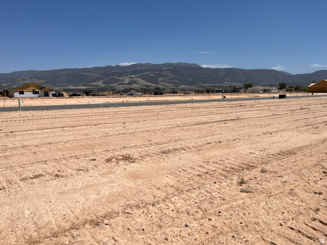 5119 North 75 East, Unit 208 Enoch, UT 84721 - Photo 2 of 14 Expansive vacant lot featuring a cleared, level surface and distant mountain backdrop