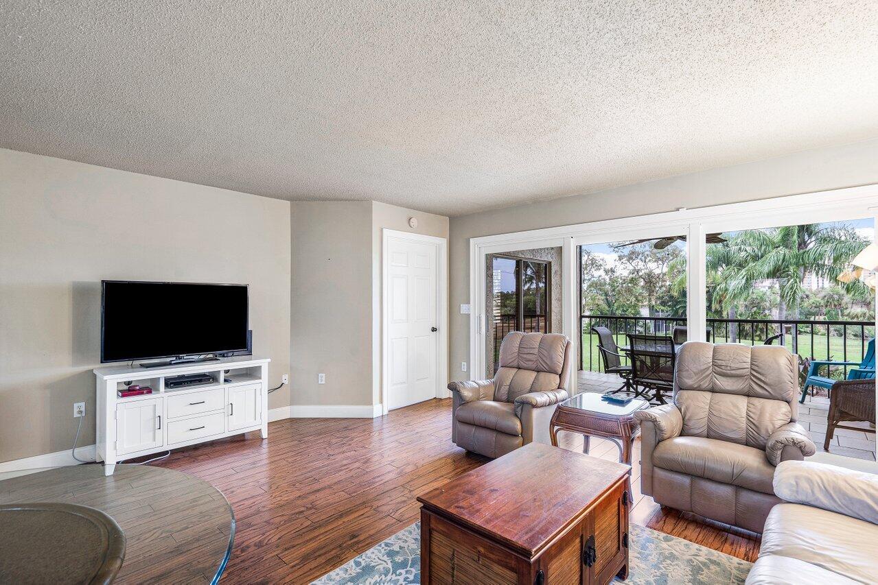275 Palm Avenue, Unit C206 Jupiter, FL 33477 - Photo 12 of 25 a living room with furniture and a flat screen tv