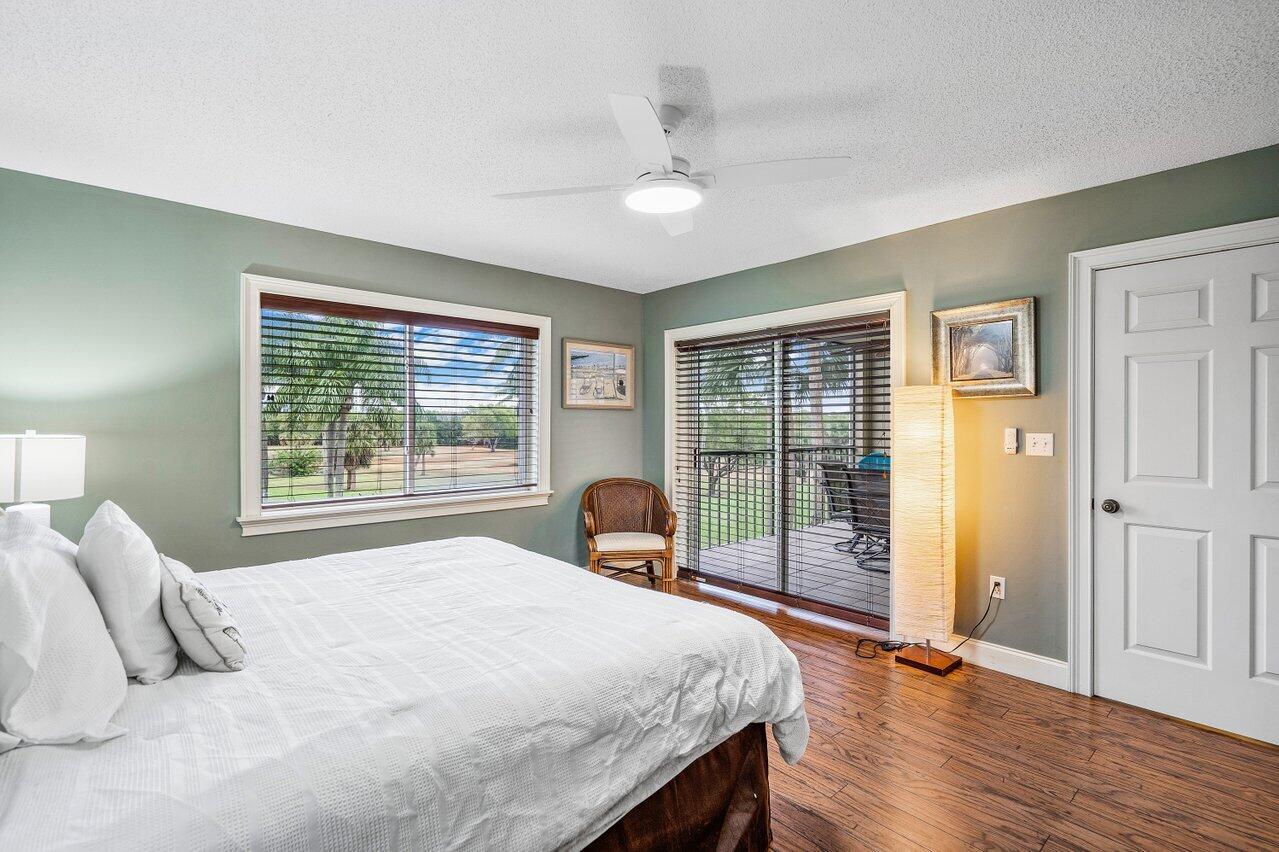 275 Palm Avenue, Unit C206 Jupiter, FL 33477 - Photo 15 of 25 a bedroom with a bed and wooden floor