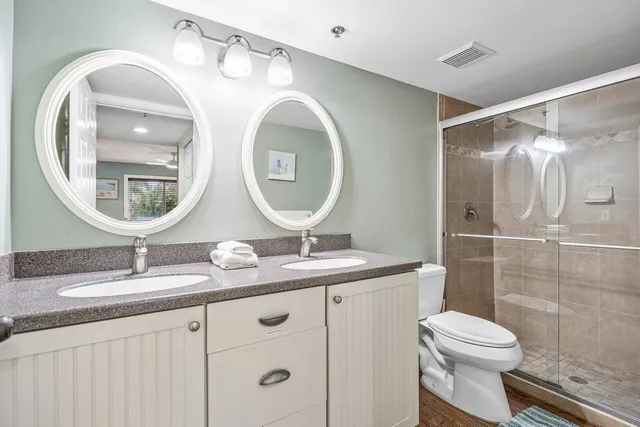 a white toilet sitting next to a bathroom sink