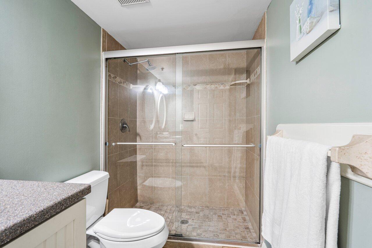 275 Palm Avenue, Unit C206 Jupiter, FL 33477 - Photo 18 of 25 a white toilet sitting next to a bathroom sink