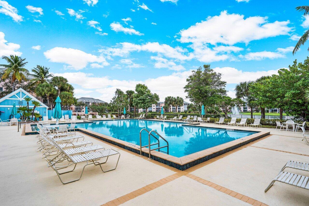 275 Palm Avenue, Unit C206 Jupiter, FL 33477 - Photo 24 of 25 a view of swimming pool with outdoor seating and plants