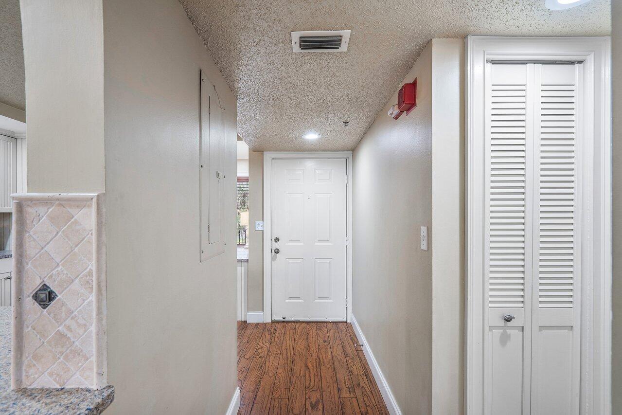275 Palm Avenue, Unit C206 Jupiter, FL 33477 - Photo 4 of 25 a view of a hallway with wooden floor and closet area