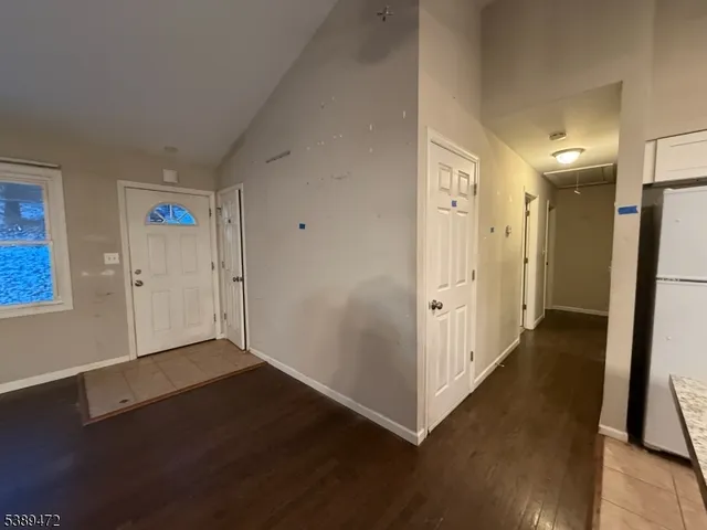 an empty room with wooden floor and a bathroom