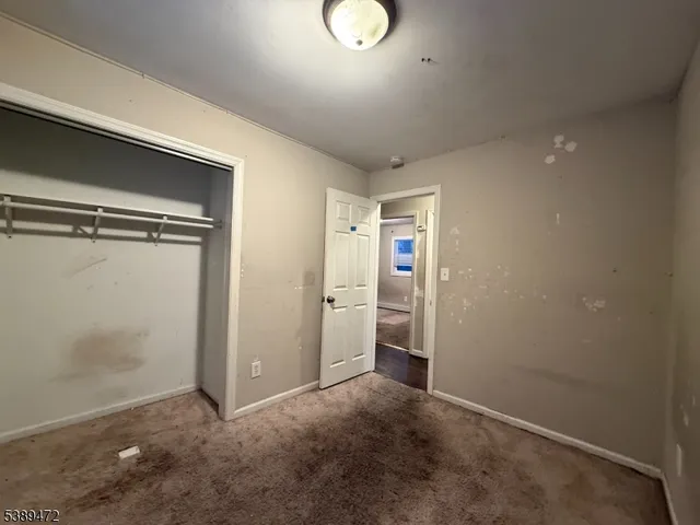 an empty room with closet and mirror