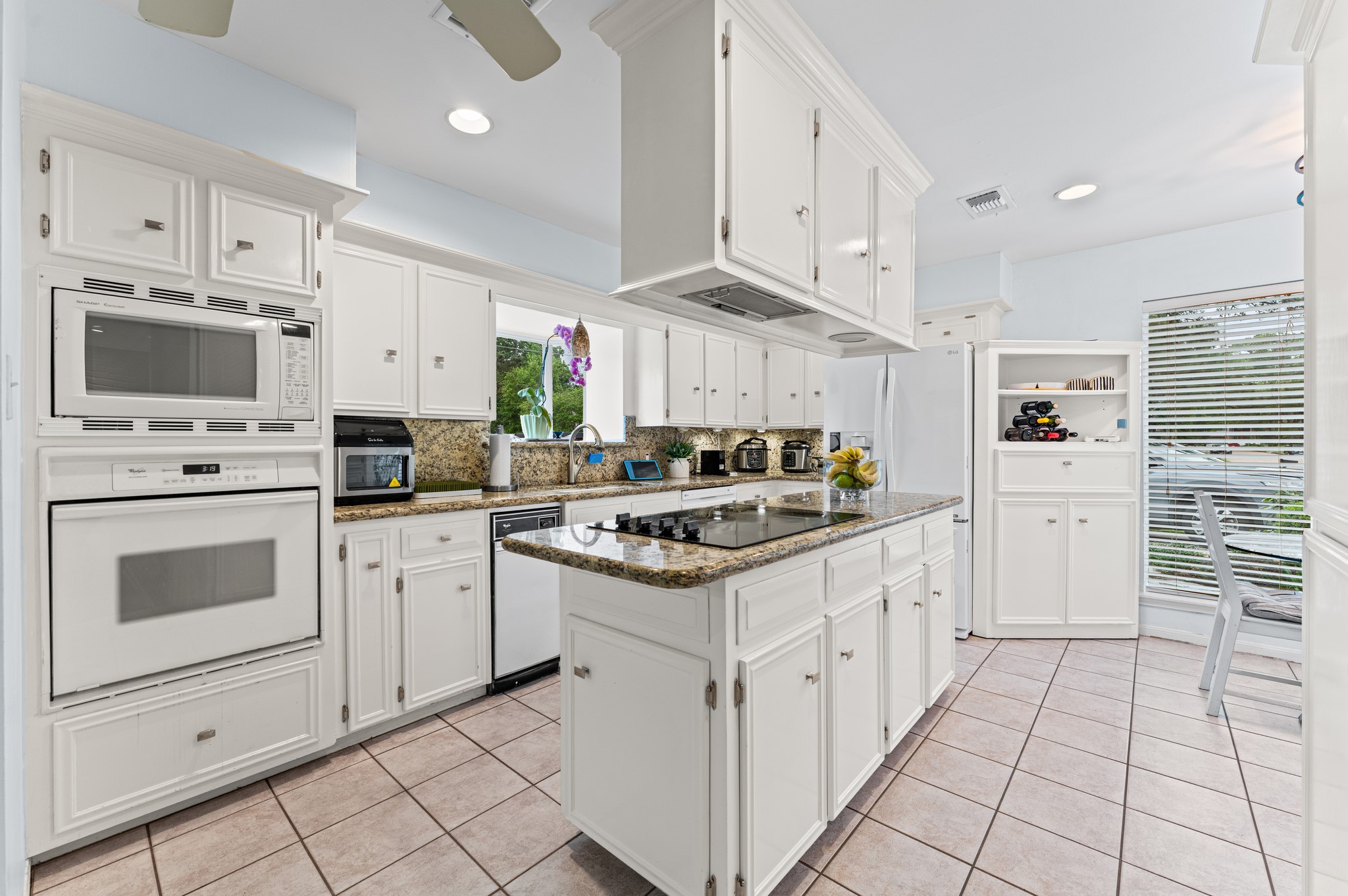 17403 Butte Creek Road Houston, TX 77090 - Photo 9 of 39 Kitchen with central island and cooktop.