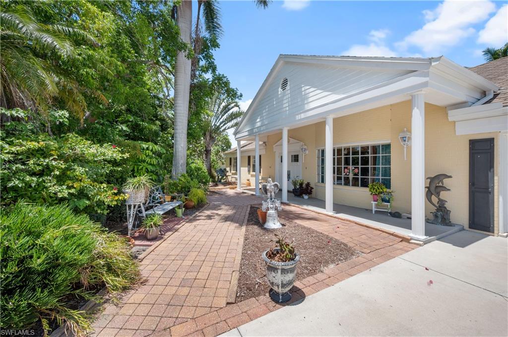 397 Forest Hills Boulevard Naples, FL 34113 - Photo 2 of 29 Angled view o front of structure. Beautiful landscaped yard allows for privacy from the road.