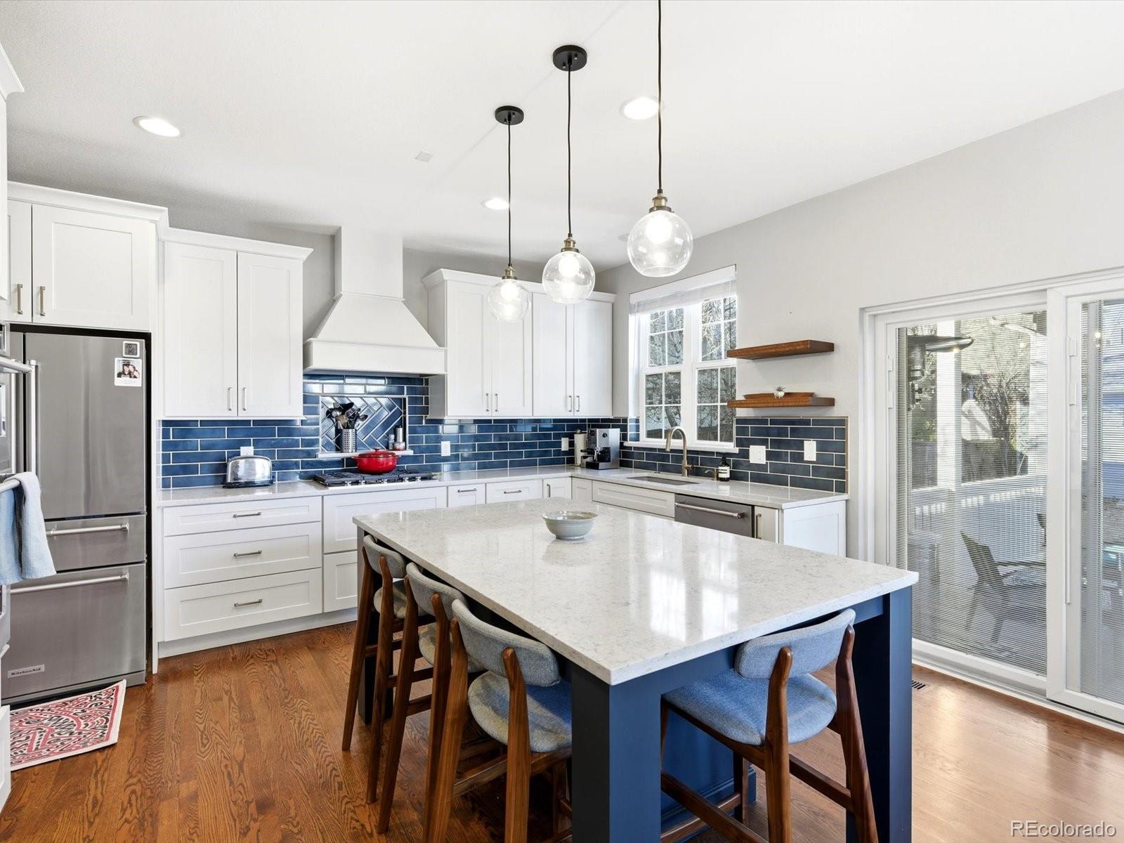 2691 Spruce Street Denver, CO 80238 - Photo 1 of 36 a kitchen with stainless steel appliances a table a stove a refrigerator and wooden floor