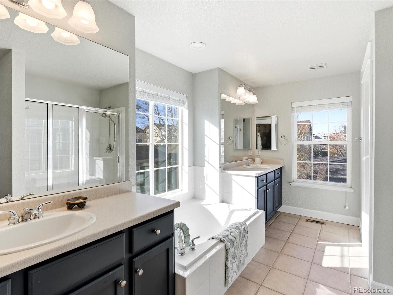 2691 Spruce Street Denver, CO 80238 - Photo 23 of 36 a spacious bathroom with a granite countertop sink a mirror and a bath tub