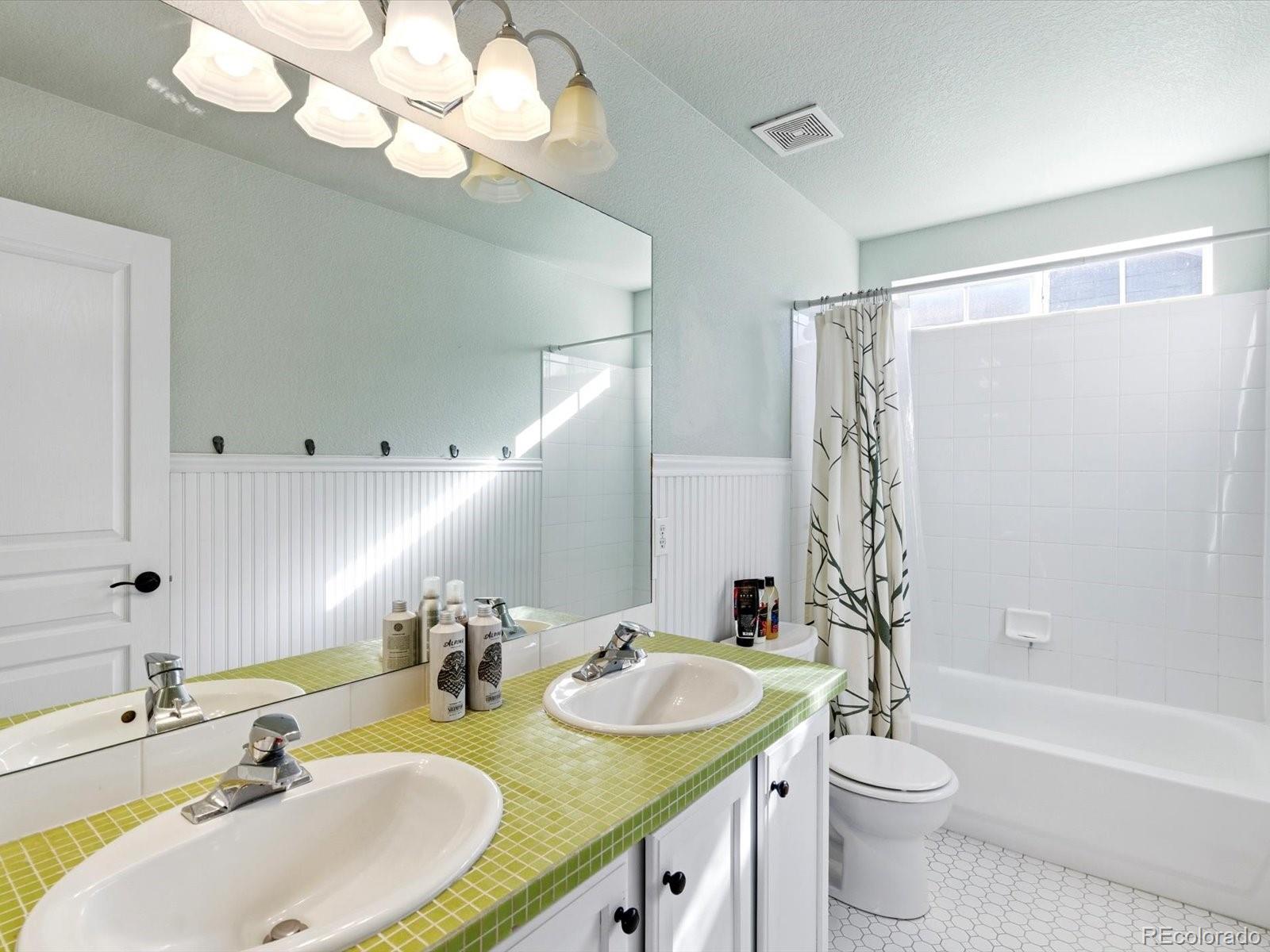 2691 Spruce Street Denver, CO 80238 - Photo 26 of 36 a bathroom with a granite countertop sink a toilet and a large mirror