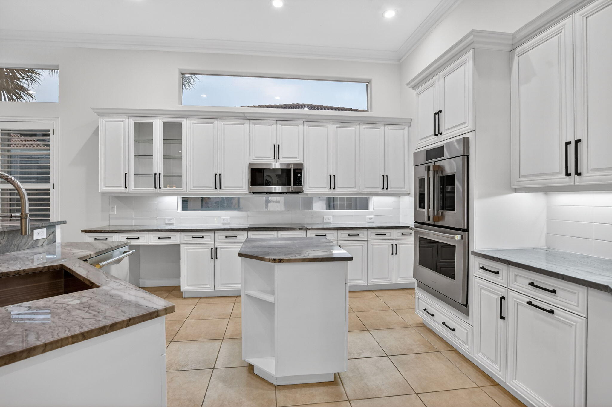 8030 Laurel Ridge Court Delray Beach, FL 33446 - Photo 20 of 87 a kitchen with white cabinets and appliances