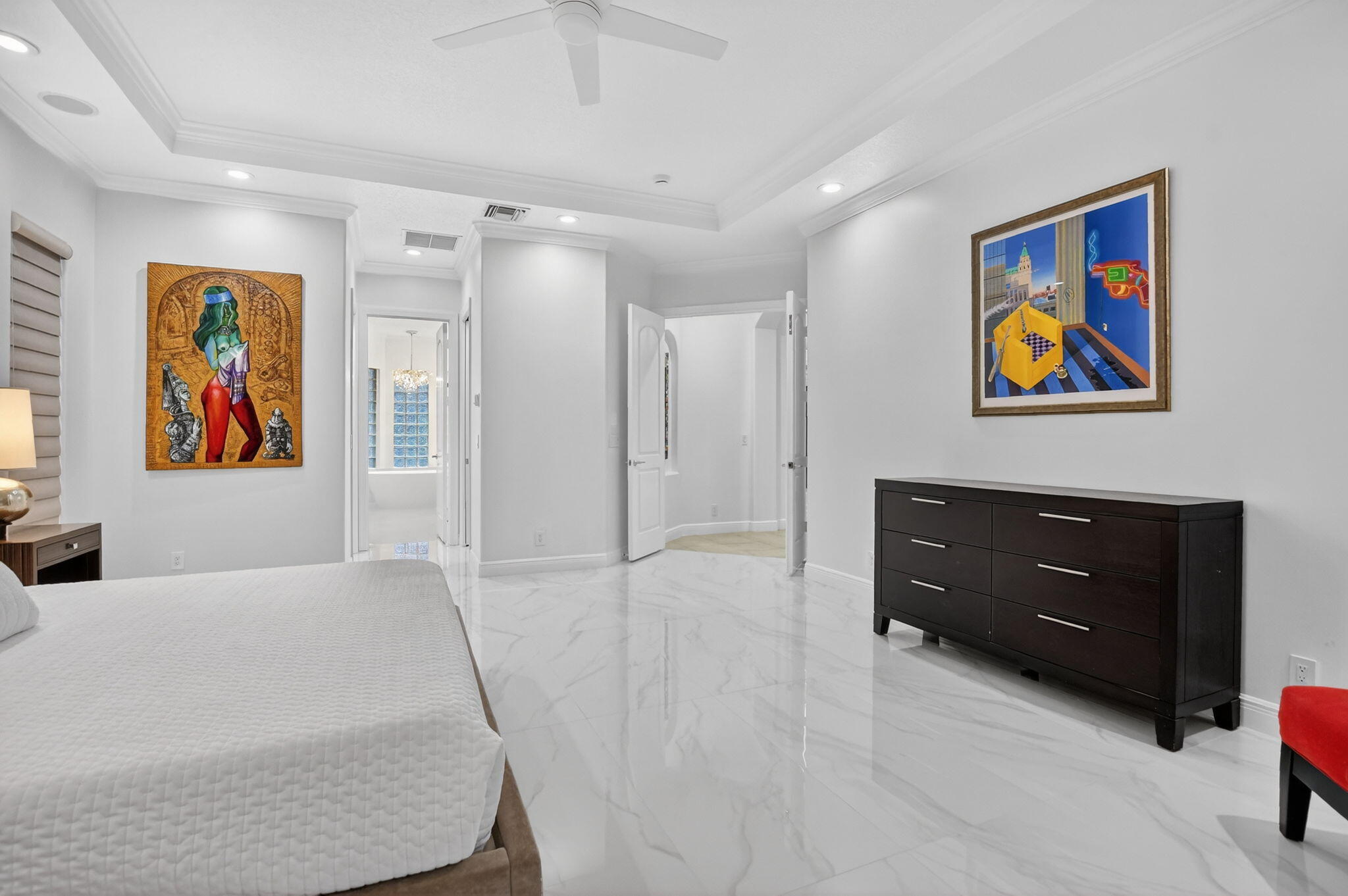 8030 Laurel Ridge Court Delray Beach, FL 33446 - Photo 40 of 87 a spacious bedroom with a bed and painting on the wall