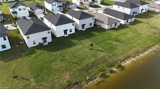 an aerial view of residential houses with outdoor space and pool