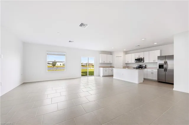 a view of a kitchen with refrigerator and microwave