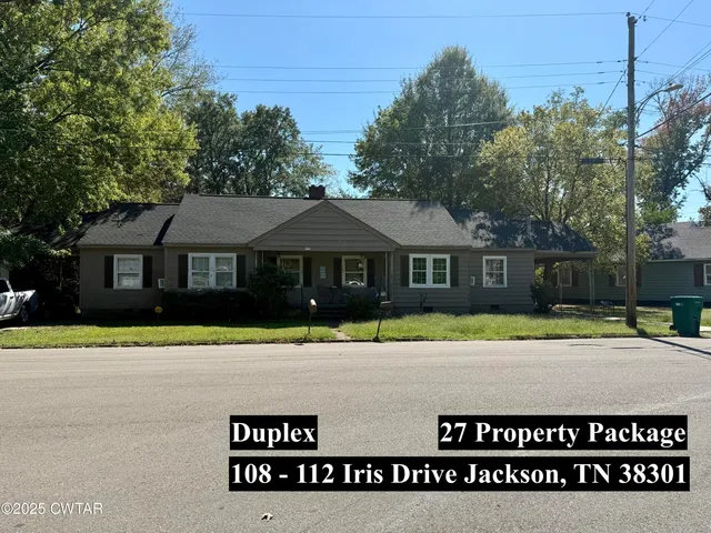a front view of a house with a yard and a garage