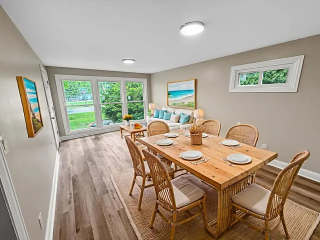a view of a dining room with furniture a rug and wooden floor
