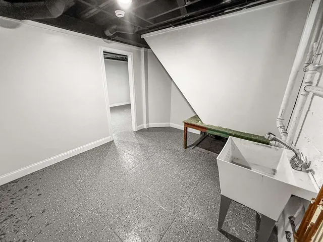 a view of an empty room with wooden floor and stairs