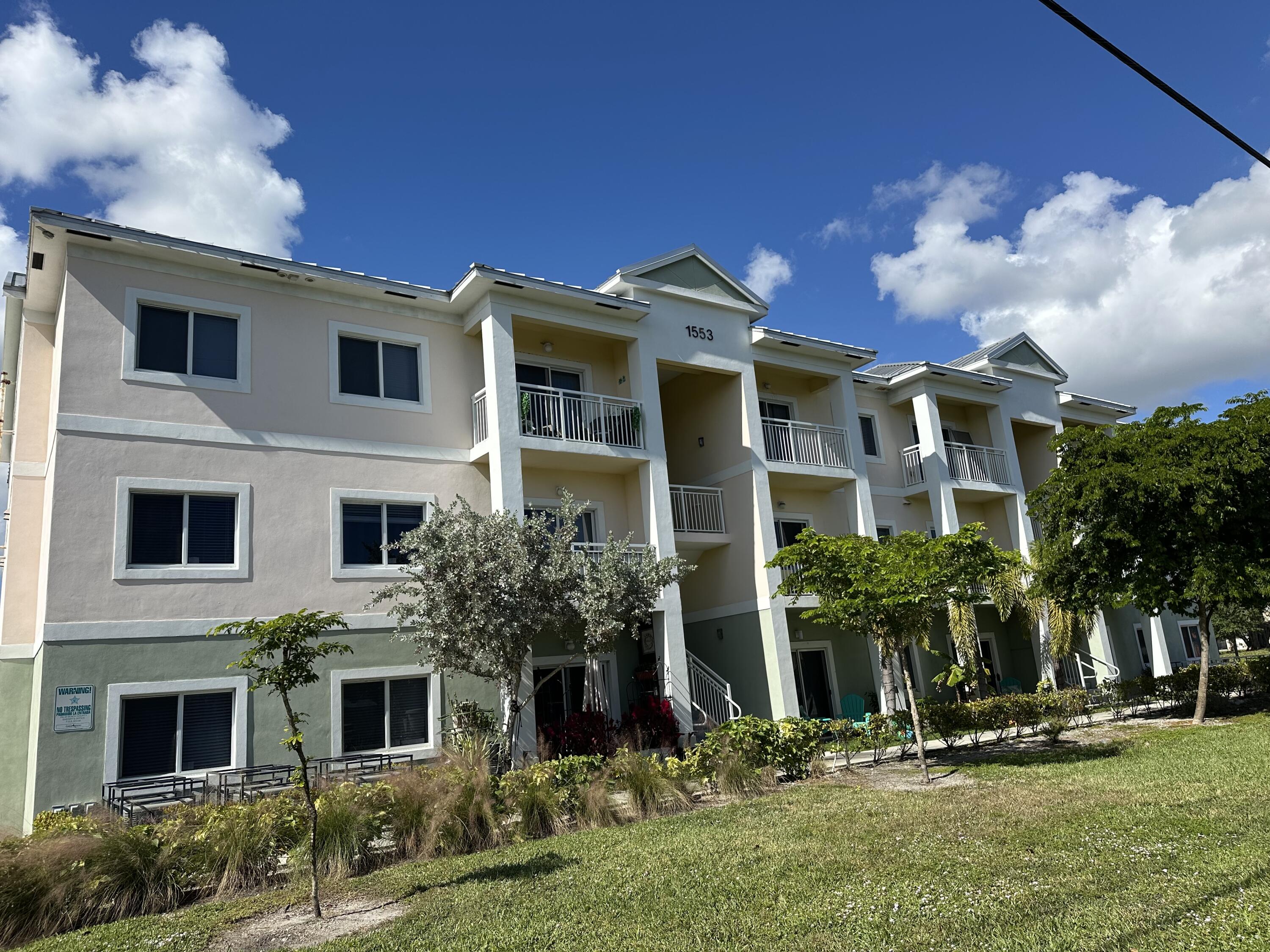 1553 Florida Mango Road, Unit 303 Palm Springs, FL 33406 - Photo 2 of 5 a front view of a house with a yard