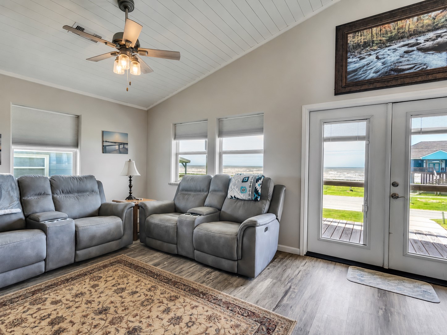 1453 County Road 230 Sargent, TX 77414 - Photo 10 of 38 Expansive water views and abundant natural light fill the space through large windows and glass doors, creating a bright, airy atmosphere and an inviting connection to the waterfront