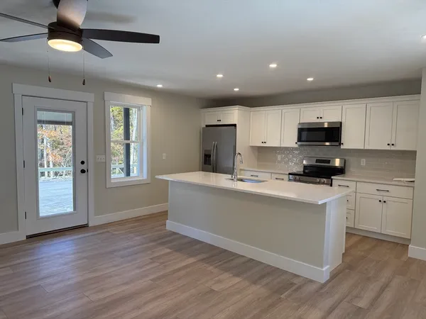 a kitchen with granite countertop a stove top oven a sink a counter space and cabinets