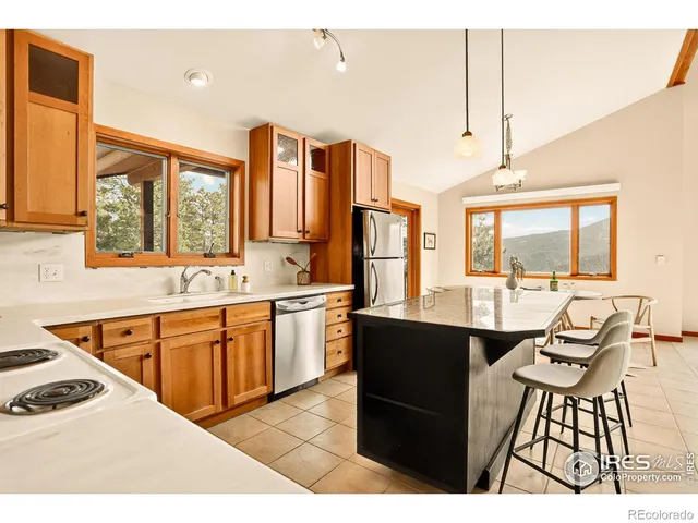 a kitchen with stainless steel appliances kitchen island granite countertop a sink and cabinets