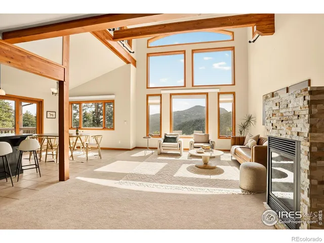 a living room with fireplace furniture and a large window