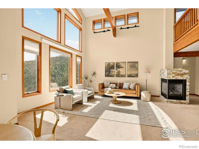 a living room with furniture a fireplace and a large window