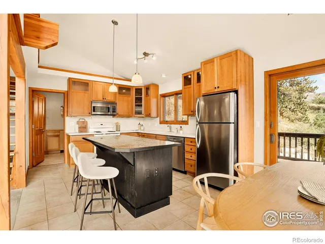a kitchen with stainless steel appliances granite countertop a refrigerator a sink a stove and a microwave