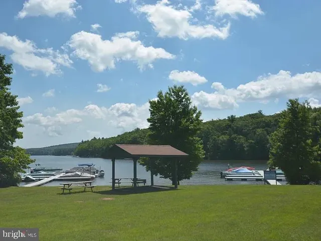 a view of a swimming pool with lawn chairs under an umbrella