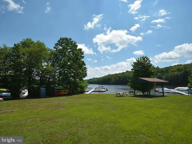 a front view of a house with garden and trees