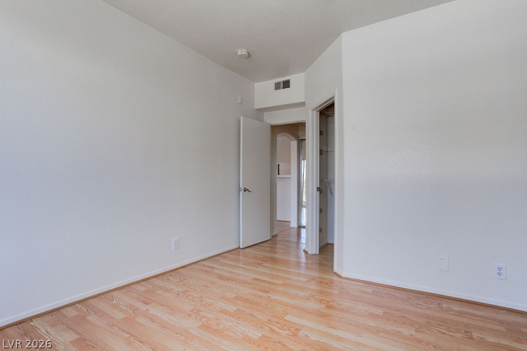 2201 Ramsgate Drive, Unit 326 Henderson, NV 89074 - Photo 29 of 44 Empty room with light wood-style floors and arched walkways