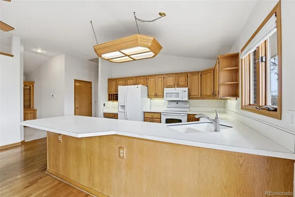 a kitchen with stainless steel appliances granite countertop a sink a stove and a refrigerator