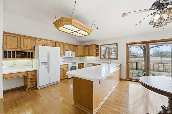 a large white kitchen with a stove a refrigerator a oven with wooden cabinets