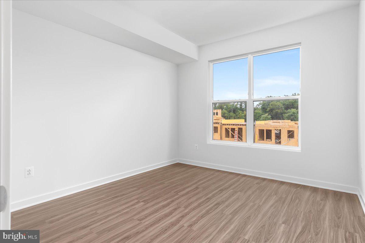 709 Iron Frg Road, Unit A Frederick, MD 21702 - Photo 13 of 15 an empty room with wooden floor and windows