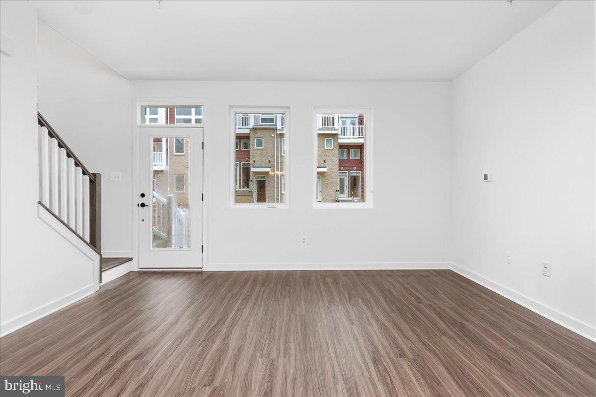 709 Iron Frg Road, Unit A Frederick, MD 21702 - Photo 4 of 15 a view of an empty room with wooden floor and a window