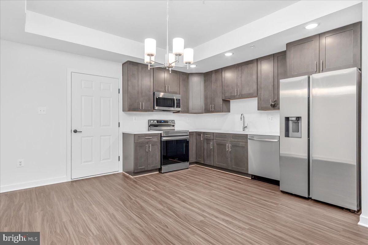 709 Iron Frg Road, Unit A Frederick, MD 21702 - Photo 5 of 15 a kitchen with kitchen island granite countertop stainless steel appliances cabinets a sink and a counter top space