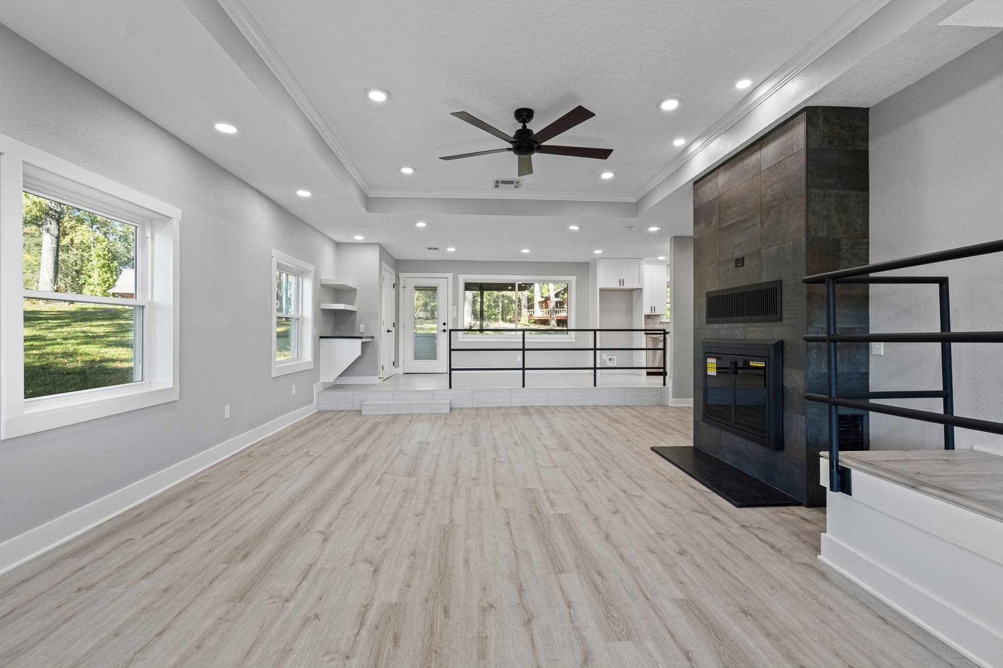 284 Hackberry Street Trinity, TX 75862 - Photo 11 of 42 an empty room with wooden floor a ceiling fan and windows