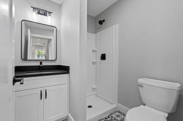 an aerial view of a residential apartment building with a yard and parking space