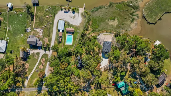 an aerial view of a residential apartment building with a yard and parking space