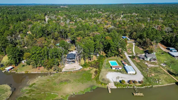 an aerial view of residential houses with outdoor space and trees