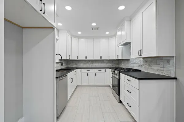 a kitchen with granite countertop white cabinets and white appliances