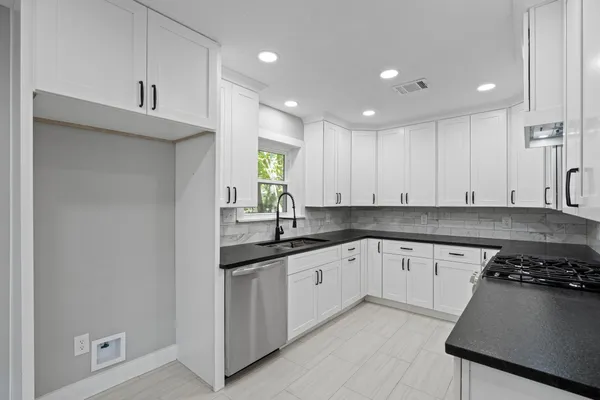 a kitchen with granite countertop a sink and cabinets